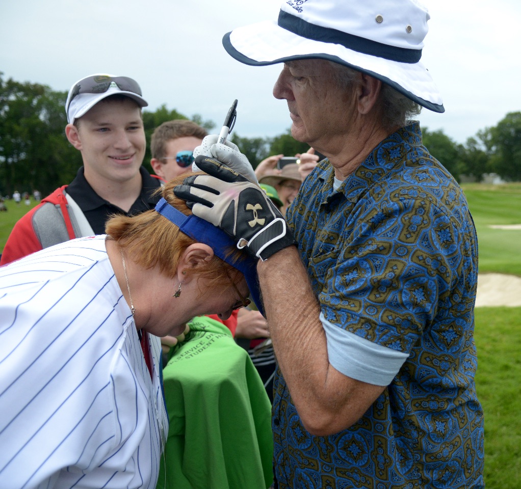 Actor Bill Murray signs the top of Carol Near, of East Moline, who asked him not to sign her $200 Ernie Banks Cubs jersey but sign her hat instead. Murray pretended not to hear her and signed the top of her head. (Photo by Todd Mizener - Dispatch/Argus)