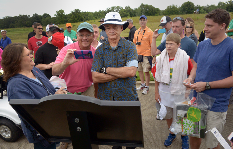 Bill Murray reads a placard at the 10th tee while a fan tries to sneak a selfie with the Academy Award nominated actor during the John Deere Classic Pro-Am, Wednesday July 8, 2015, in Silvis. (Photo by Todd Mizener - Dispatch/Argus)