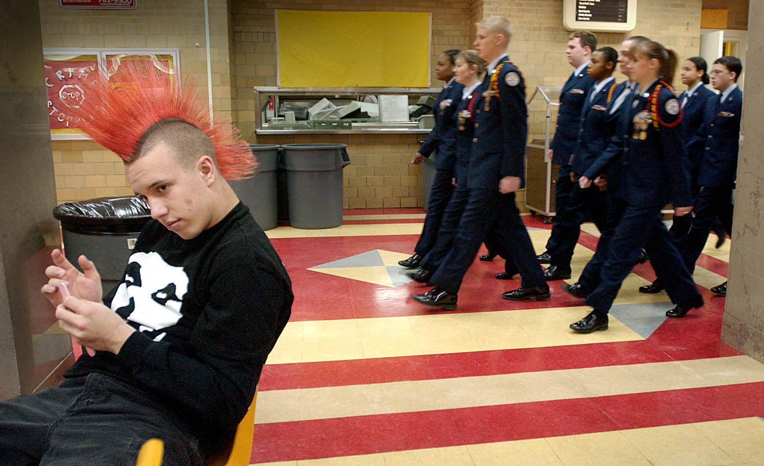 Members of the Rock Island High School Air Force Junior R.O.T.C. strike a distinct contrast to the rest of the student body as they march through the school's cafeteria while Rocky junior Richie Rowe sits in study hall filing his nails. Many of the cadets plan to serve in the armed forces after high school graduation. 