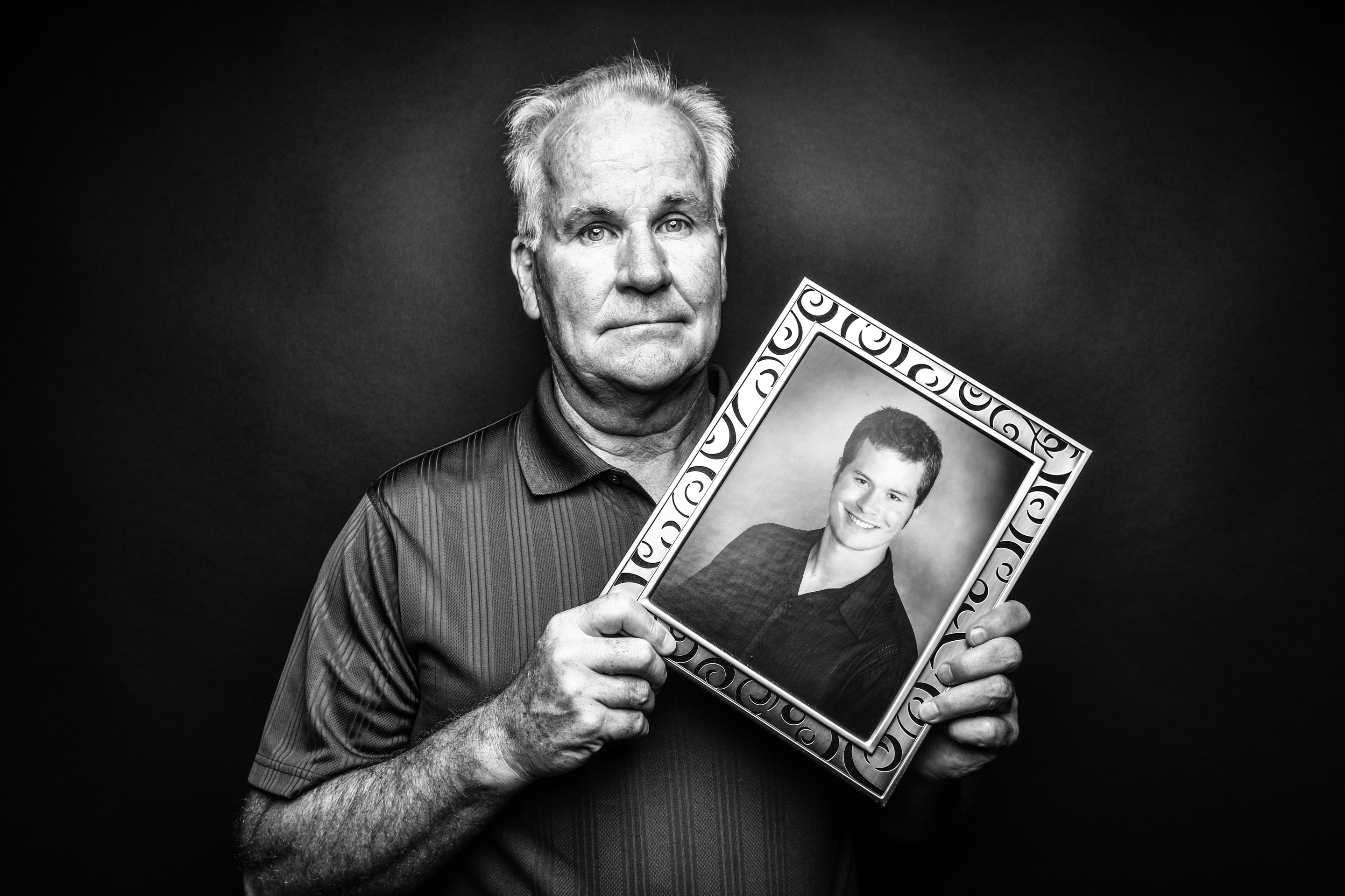 Dave Hansen, Bettendorf, holds a photo of his son Daniel, who died by suicide at 20, in 2005.