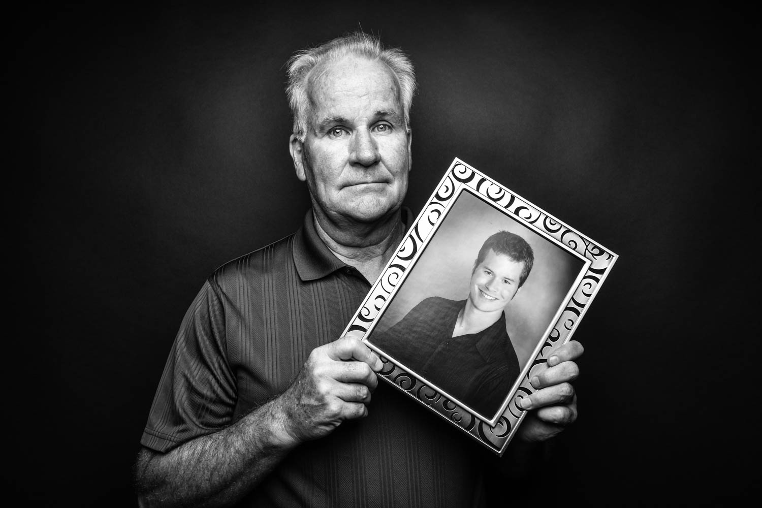 Left Behind by Suicide: Dave Hansen, Bettendorf, Iowa, poses with a photo of his son Daniel, who died by suicide, at 20, in 2005.  