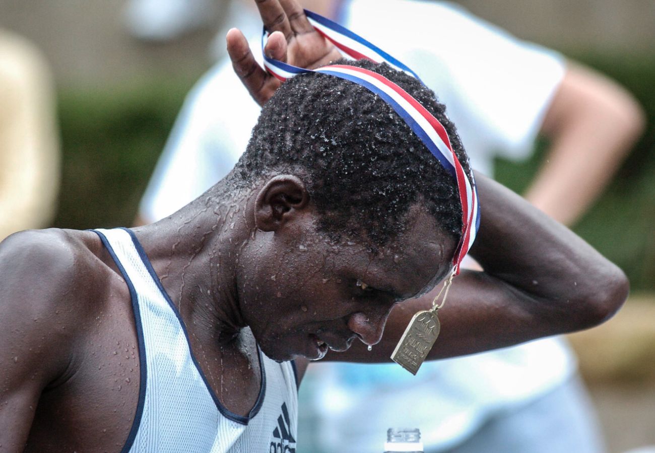 An exhausted Paul Rugut, 34, of Kenya, drapes his medal over his head after capturing first place in the 2005 Quad-Cities Marathon. The newcomer to the QCM won the race on a wet and humid morning with a time of 2:20:27. (Todd Mizener - Dispatch/Argus)